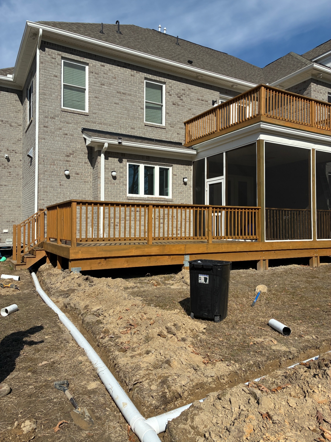 Drainage line installation beside a raised deck at a Hampton Roads home